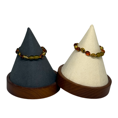 Two cone-shaped jewelry stands with a bracelet on a white background